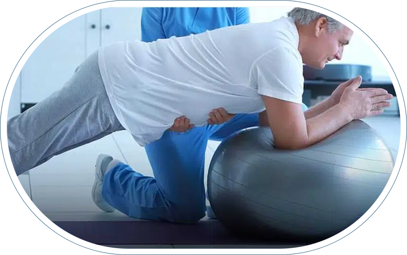 Man balancing on a yoga ball during a physical therapy session at his local orthopedic clinic.