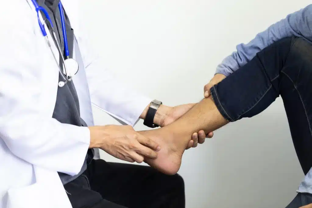 A foot and ankle orthopedic surgeon is checking the feet of a patient with diabetic foot problems.